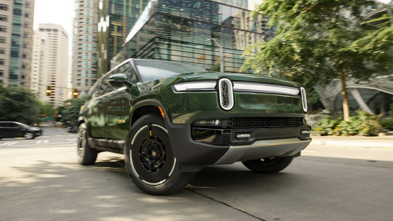 A pair of Rivian R1S SUVs plugged in at an electric charging station
