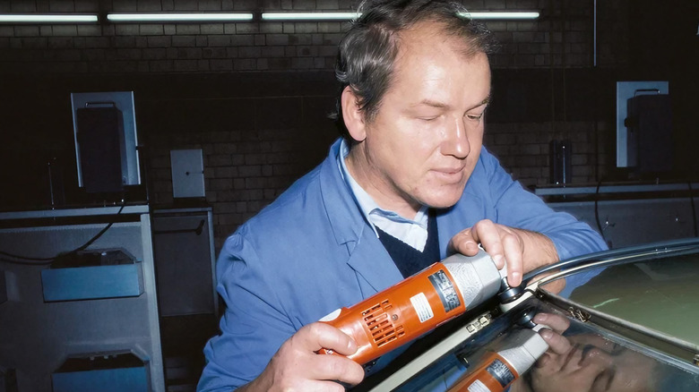 a man works the Fein oscillating tool on a car