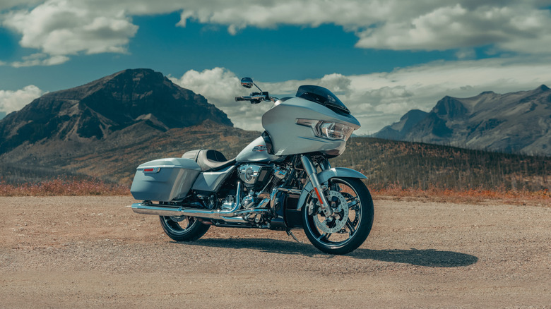 A silver Harley-Davidson Road Glide, front 3/4 view, mountains in the background