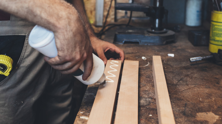 Person applying PVA glue to wood