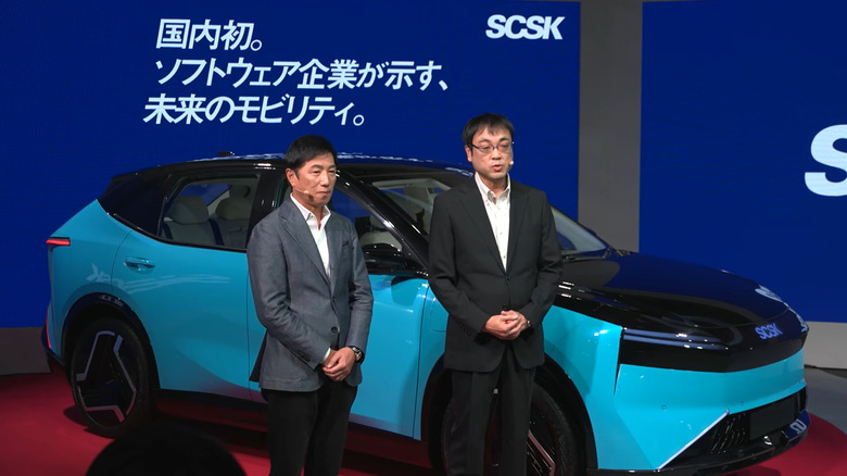 SCSK executives standing next to the new concept car