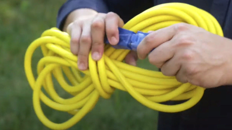 Person wrapping extension cord