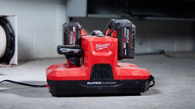 A Milwaukee M18 and M12 Four Bay Simultaneous Super Charger charger with four batteries connected.