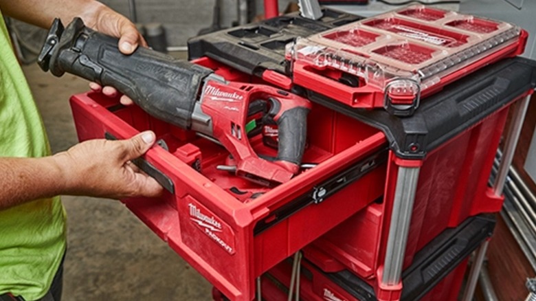 A person grabbing a tool from a Milwaukee Packout container.