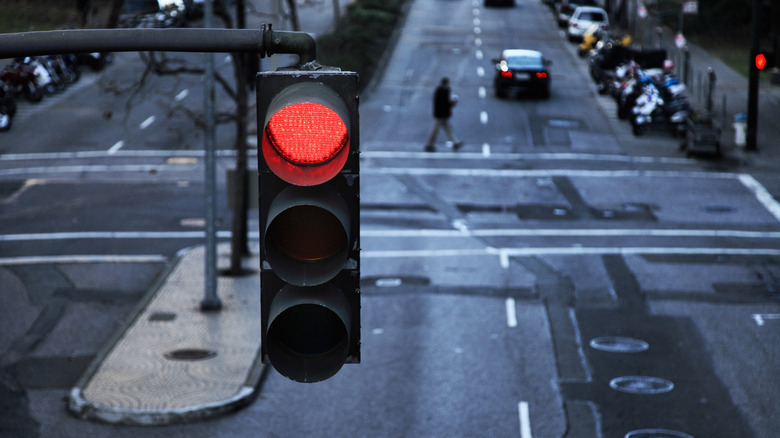 An view from above a red light hanging on a wet, dark street