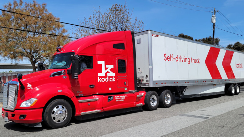 Red and white Kodiak Robotics self-driving truck on the road.
