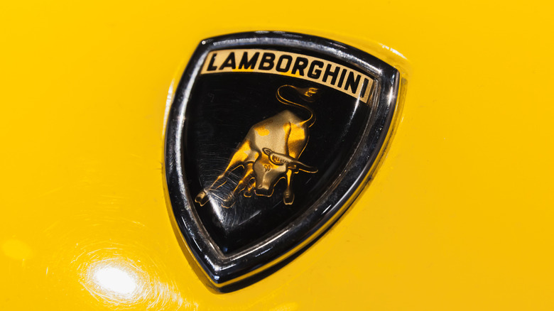Close-up of a Lamborghini logo on a yellow Lamborghini Miura