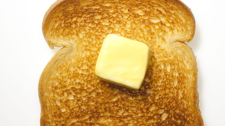 A slice of toast with butter melting on the top.