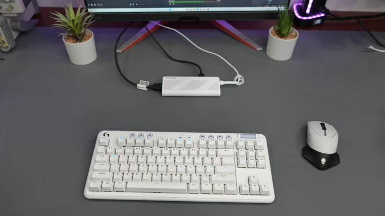 Mini PC stick plugged into desktop gaming setup