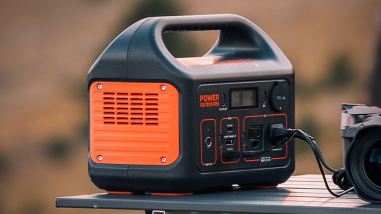 Jackery Explorer 300 plugged into camera on picnic table