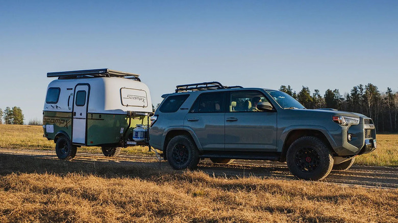 Toyota 4Runner towing a Scamp X on a dirt road