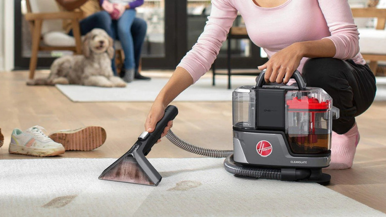 Woman using a Hoover vacuum on carpet in the living room