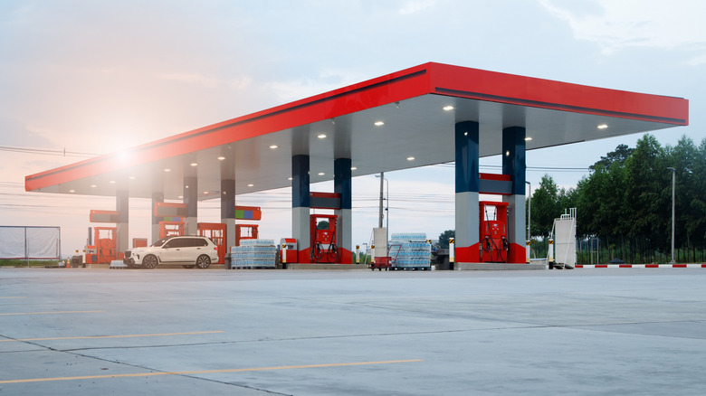 Generic gas station during sunset with red pumps and roof