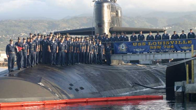 The crew of the USS Louisville (SSN-724) standing atop the boat