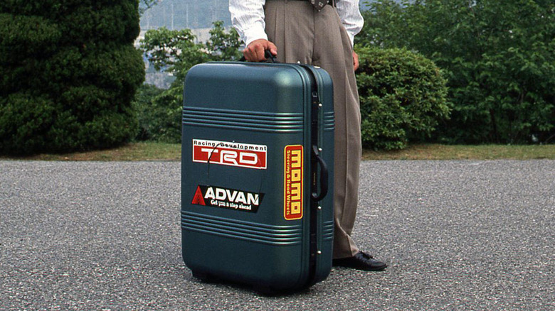 Person holding Mazda suitcase car packed up