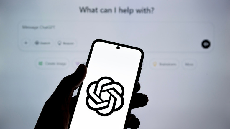 person holding phone with ChatGPT logo on screen