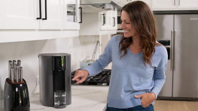 Woman smiling and standing next to C1H RO System