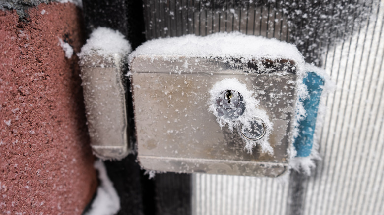 Door lock covered with snow and frost