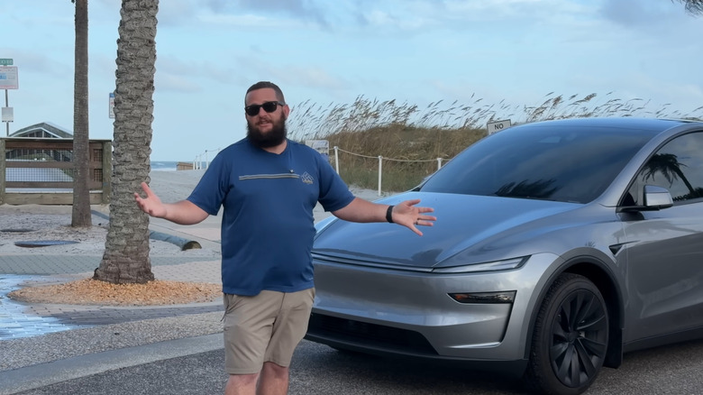 Bearded Tesla Guy withstanding by a Model Y parked by a palm tree