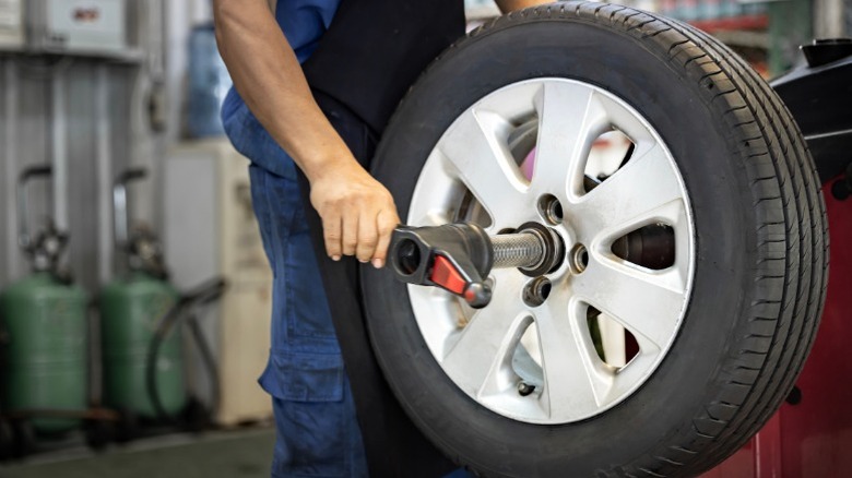 A mechanic mounting a wheel and tire on a tire balancing machine