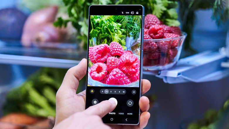 Person taking a photo of raspberries with Samsung Galaxy S25 Ultra