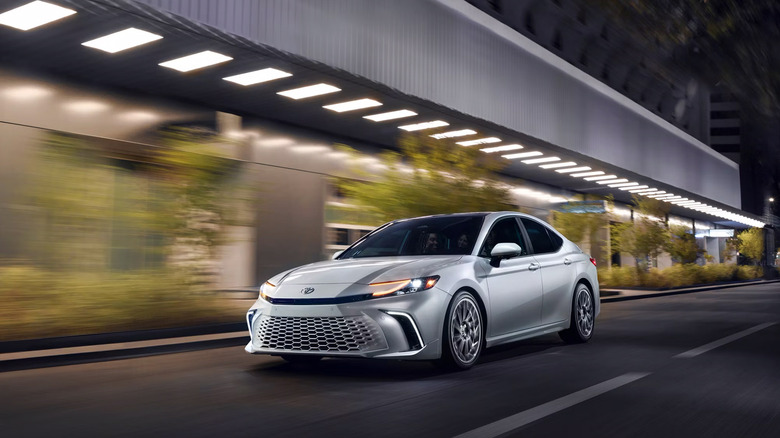 A white 2025 Toyota Camry driving