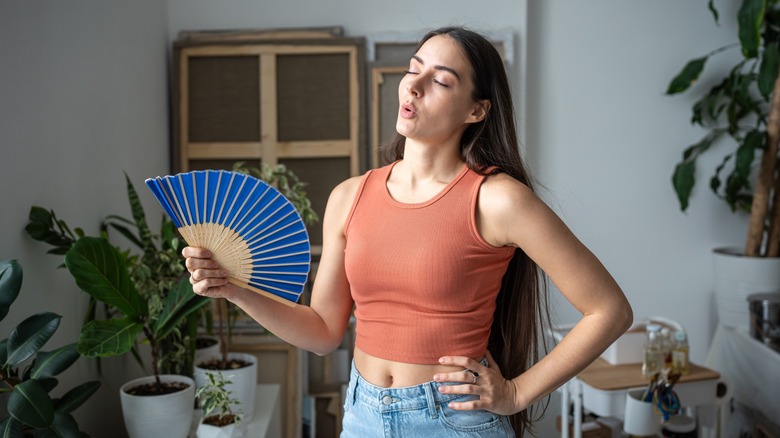 A woman trying to stay cool in her home.