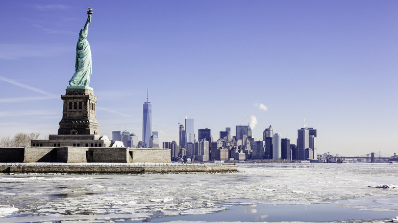 Ice surrounded the Statue of Liberty in New York Harbor with the World Trade Center and city skyline in the background