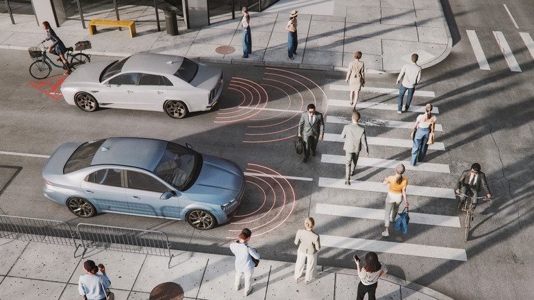 Pedestrians and bicyclists at crosswalk with cars showing detection warning graphics