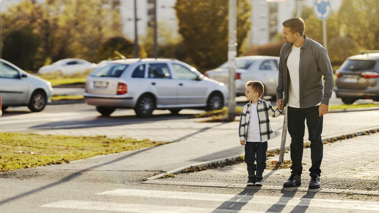 Man and child waiting to cross a crosswalk
