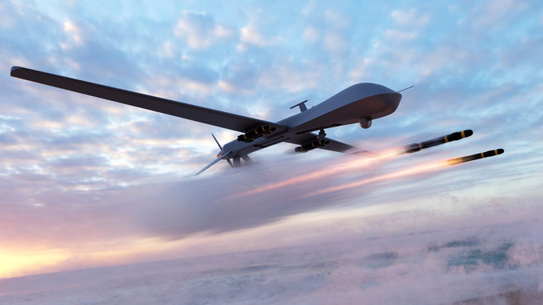 Military combat drone launching missiles in partly cloudy sky