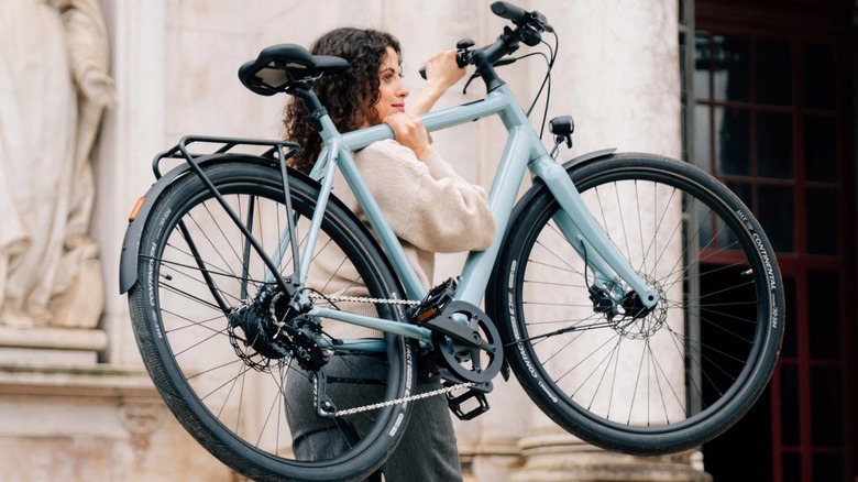 Person carrying an Ampler bike on her shoulder