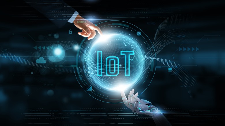 A human and robot touching an IoT hologram.