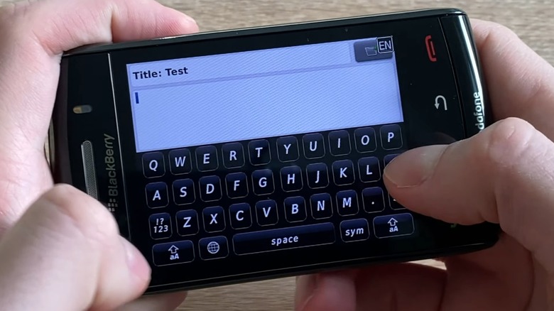 A person typing on a BlackBerry Storm.