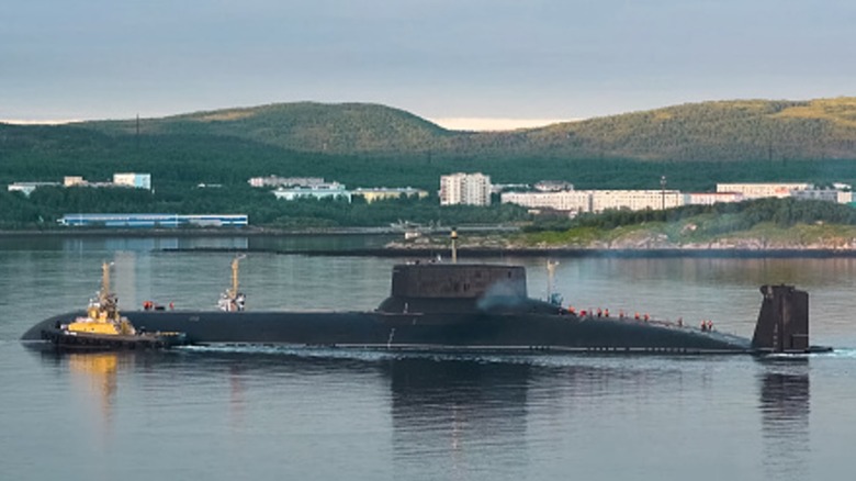 A Typhoon-class submarine surfaced in a harbor.