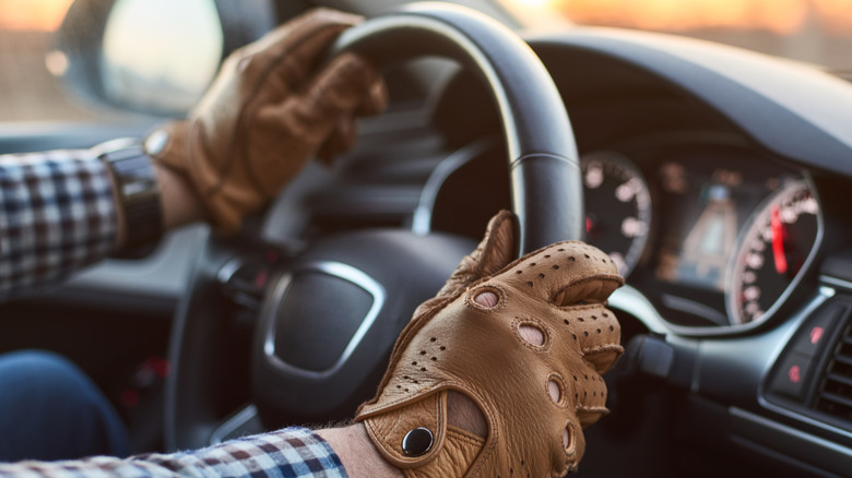 A person wearing driving gloves while driving.