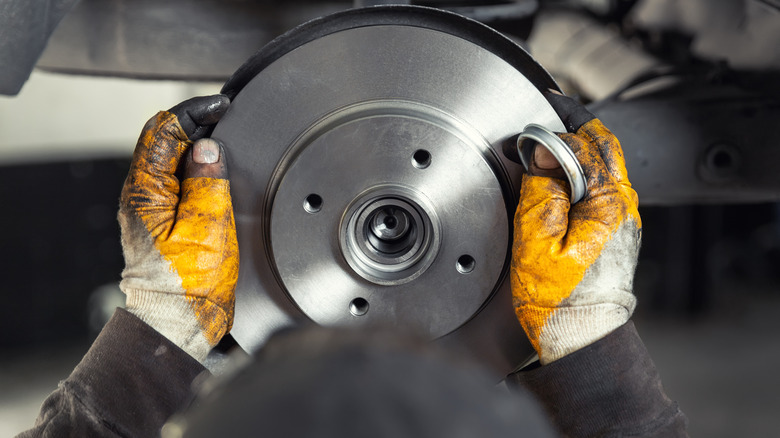 A mechanic working on a brake rotor.