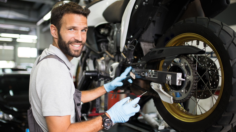 man maintaining a motorcycle