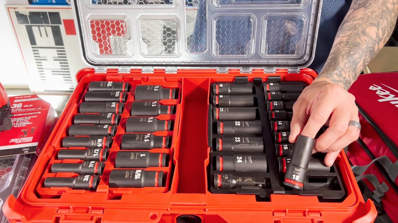 Person showcasing sockets from the Milwaukee Shockwave Packout impact socket set