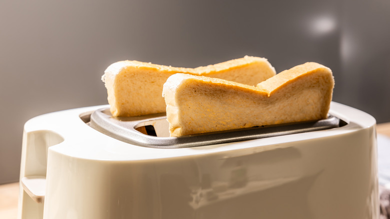 Two slices of bread in a toaster.