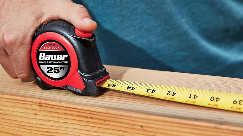 DIYer using a Bauer tape measure