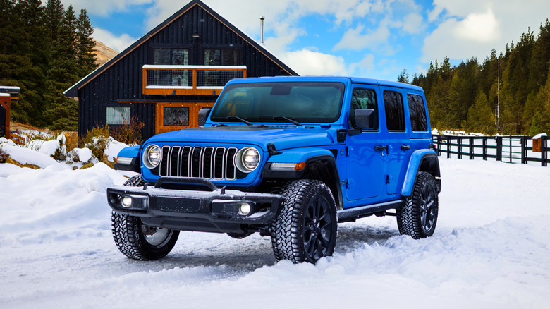 Blue Jeep Wrangler 4xe parked in the snow