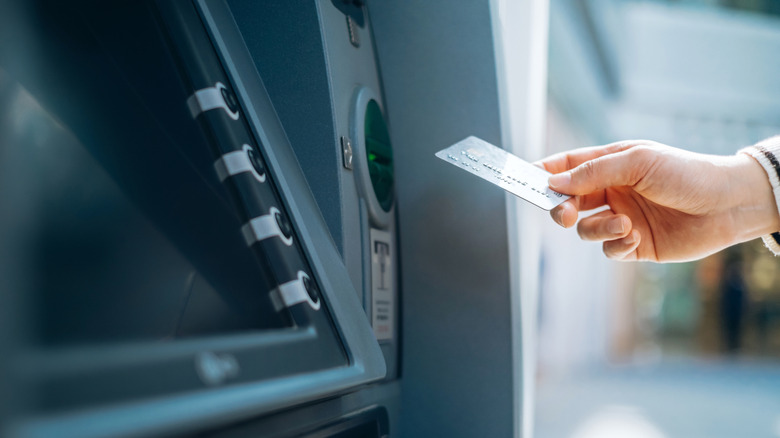 A women preparing to insert her bank card into an ATM