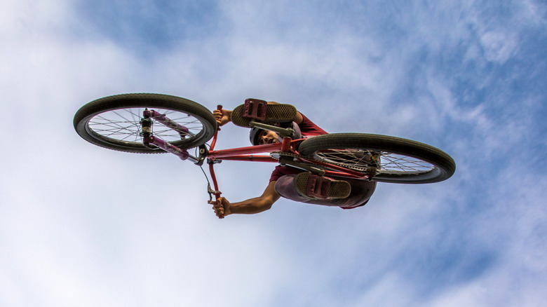 A person on a BMX bike in the air photographed from below