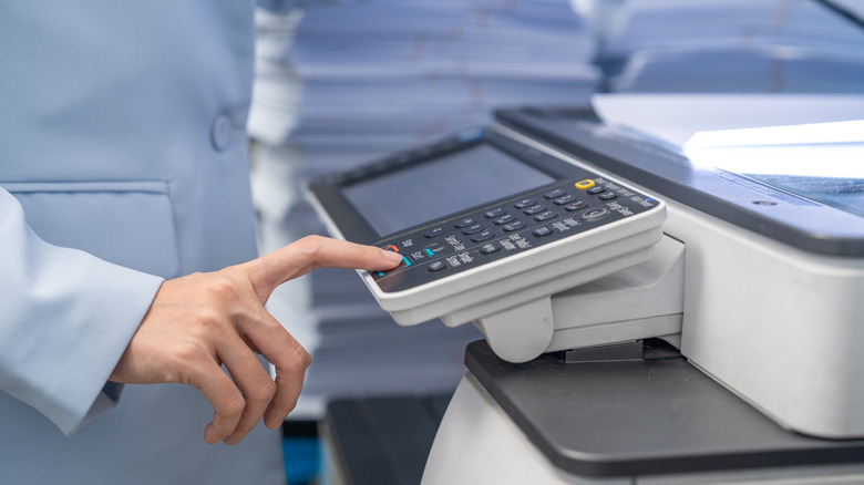 Woman pressing button on printer