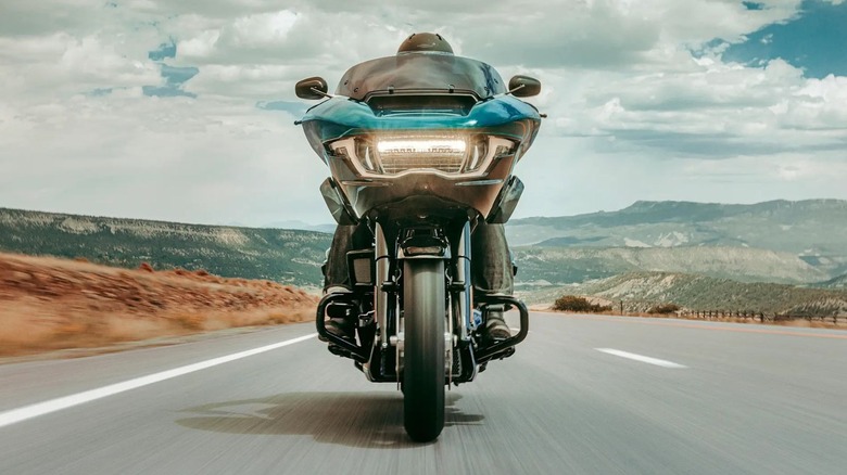 Closeup view of the front of a blue Road Glide riding down the high way
