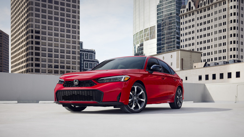 Front 3/4 shot of a Rallye Red Honda Civic Sedan with buildings in the background