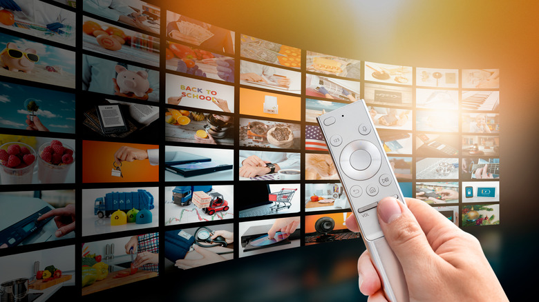 person holding remote against backdrop of video thumbnails on a SmartTV