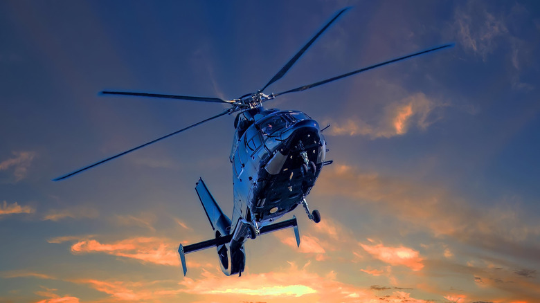 A helicopter hovering in the evening sky