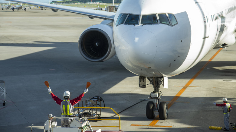 Aircraft marshall on a platform in front of a plane